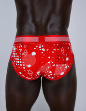 Red men's briefs underwear with a white geometric pattern, shown from the back on a male model against a light grey background.