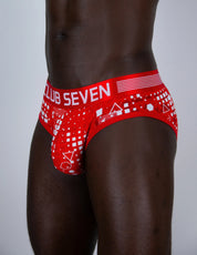 Red and white patterned men's briefs worn by a male model, featuring the text 'CLUB SEVEN' on the front waistband.